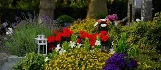 Ein Friedhof voller Blumen und einer Laterne.